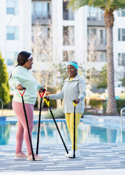 istock Two African-American women working out on pool deck 1383983220