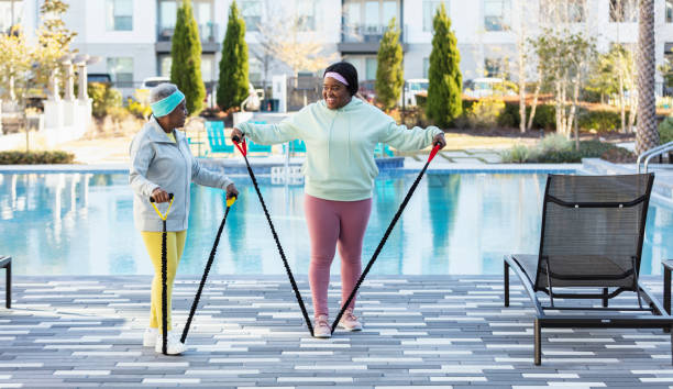 istock Two African-American women working out on pool deck 1383983243