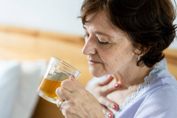 istock Woman with sore throat drinking tea 1383987421
