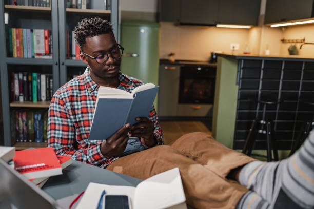 African-American man reading a book at home