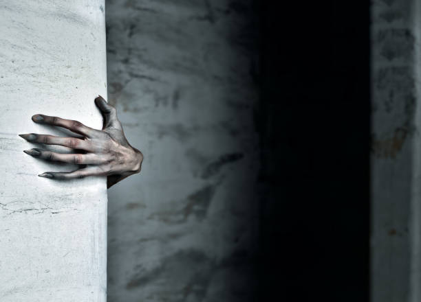 A Scary Hand Reaches out from Behind a Wall stock photo