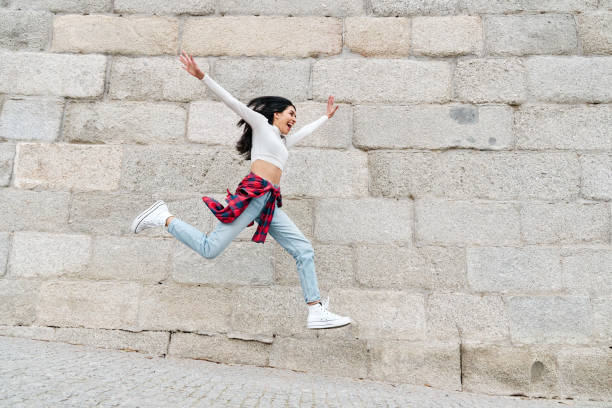 istock Woman jumping joyfully with open arms 1383994170