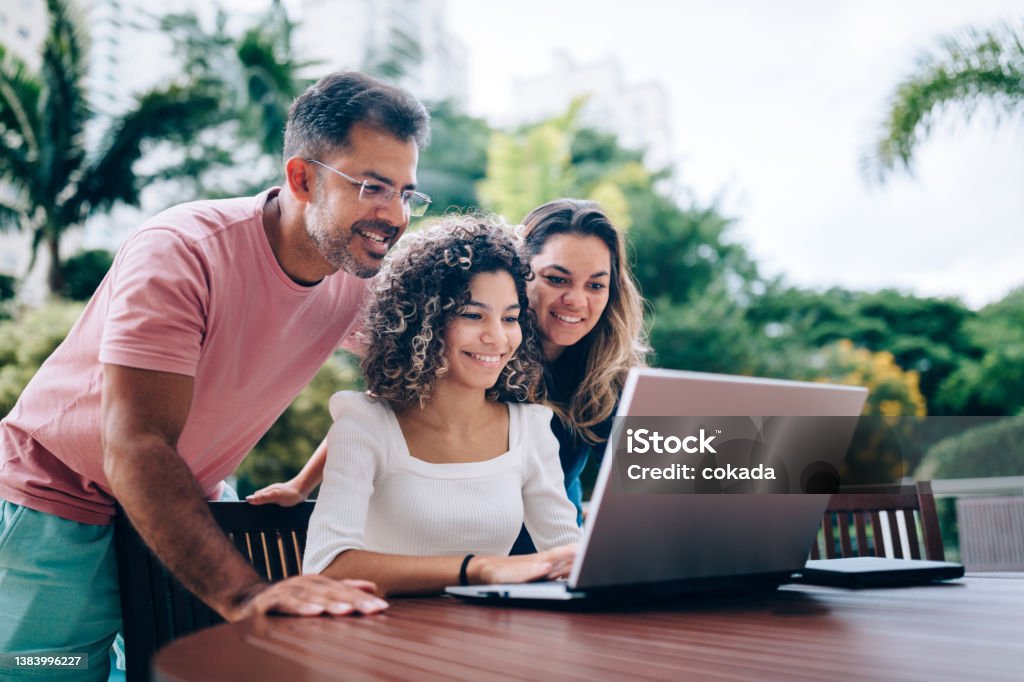 Family using laptop at resting area Teenager Stock Photo
