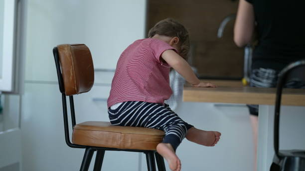 istock Child getting down from chair candid little boy steps down from high-chair 1383998078