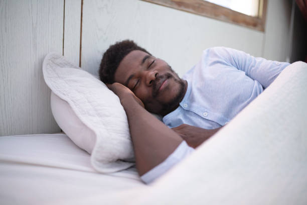 istock Black man with sore throat sleeping in bed 1384000737