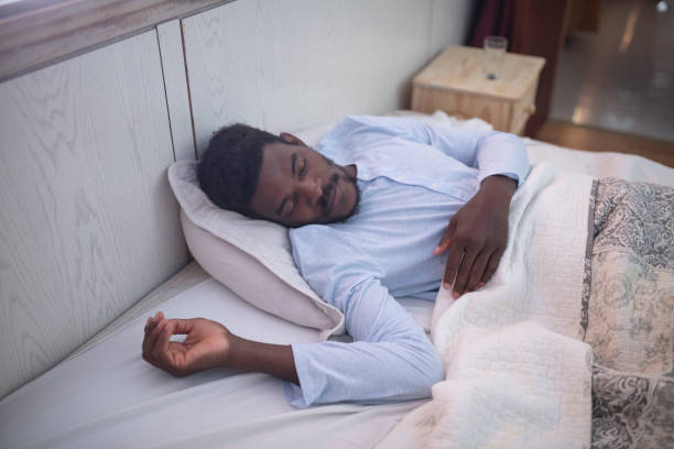 istock Black man with sore throat sleeping in bed 1384000804