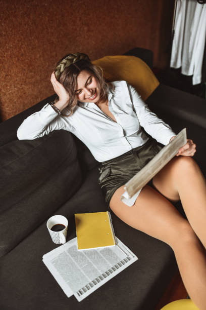 Blond Smiling Female Reading School Notes With Coffee At Home