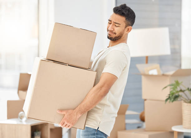 istock Shot of a young man carrying heavy boxes while moving house 1384023341