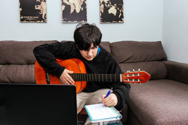 istock Young man composing a song for a spanish guitar 1384036744