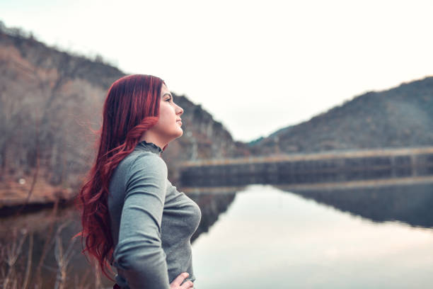 Cute Redhead Female Looking Towards The Future While Relaxing On Lake