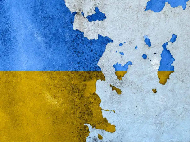 Photo of Flags of Ukraine on cracked cement of old damaged wall texture, background.
