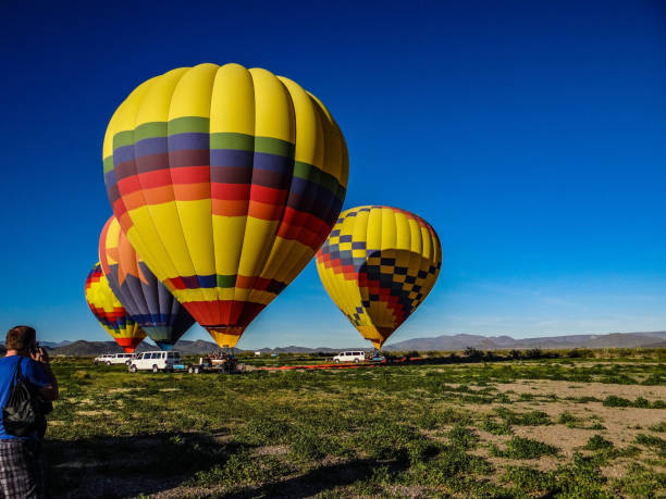 Hot air balloons awaiting departure in Arizona On February 16, 2016 outside of Scottsdale Arizona a group of 3 colorful hot air balloons await departure   Passengers are loading for a fun filled sunset viewing. levitation stock pictures, royalty-free photos & images