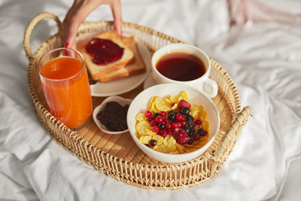 istock Tray with breakfast food on bed 1384054680