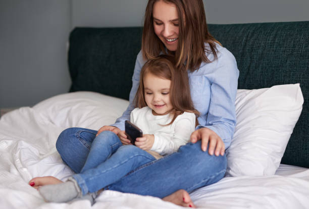 istock Mother and daughter using smartphone together 1384054757