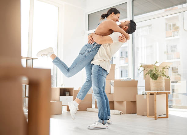 彼らの新しい家への移動を祝う若いカップルのショット - 住宅購入 ストックフォトと画像