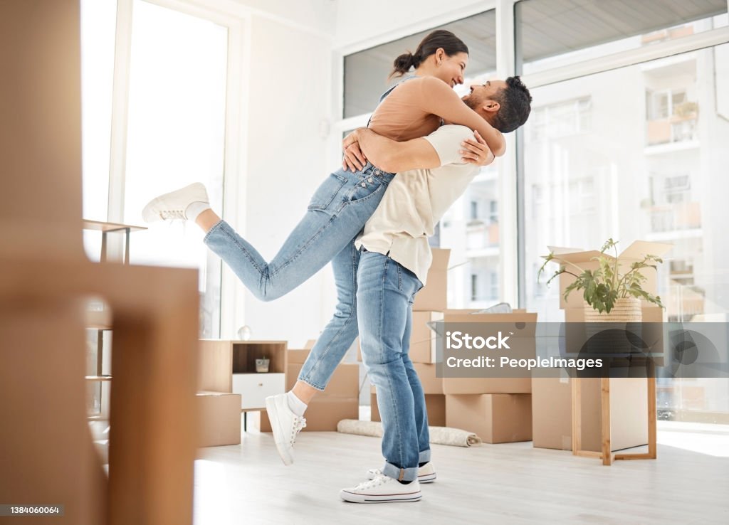 Shot of a young couple celebrating the move into their new home This all feels unreal Moving House Stock Photo