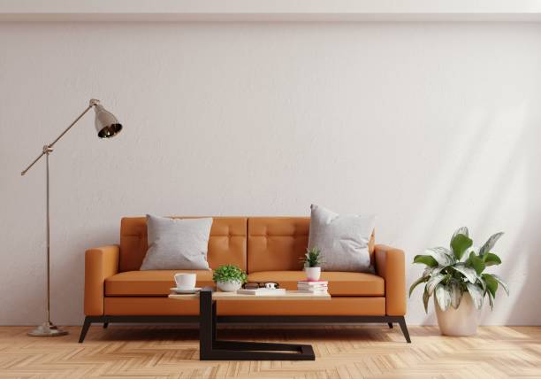 istock Living room wall mock up with leather sofa and decor on white plaster wall background. 1384064133
