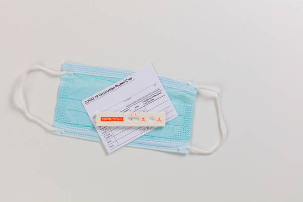 istock Rapid test device for covid 19 showing negative test result plus facemask and vaccination card 1384068043