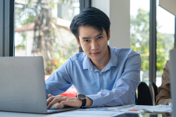 istock Asian Businessman working to analyze technical price graph and indicator with business team. account or saving money or insurance concept. 1384079544