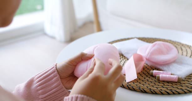 istock Close-up hand asia woman help make craft pink single fill up bra cup insert for post mastectomy prosthesis surgery MRM at home. Relief work service support give hope to tumor patient medical issue. 1384084406