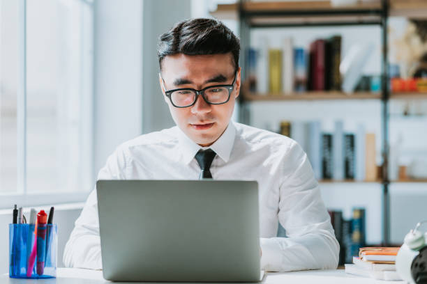 istock Young Asian businessman working at office 1384109920