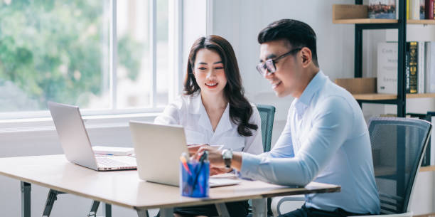 Two Asian businesspeople working at office Two Asian businesspeople working at office indonesian ethnicity stock pictures, royalty-free photos & images