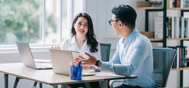 istock Two Asian businesspeople working at office 1384110500