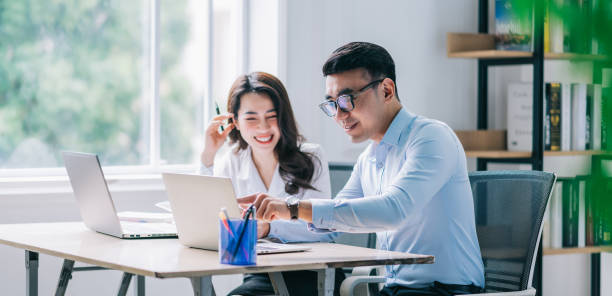 istock Two Asian businesspeople working at office 1384110504