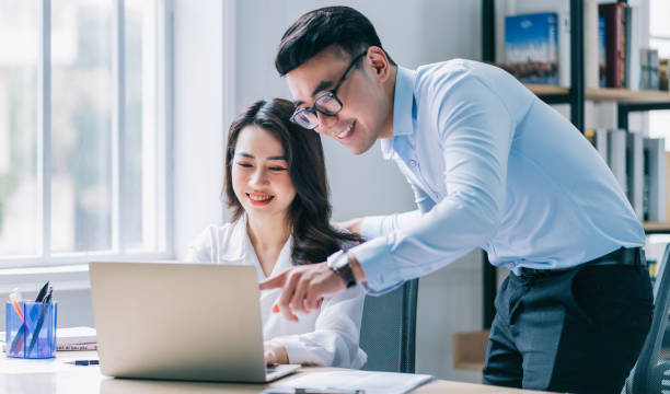 istock Two Asian businesspeople working at office 1384110512