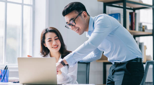 istock Two Asian businesspeople working at office 1384110513