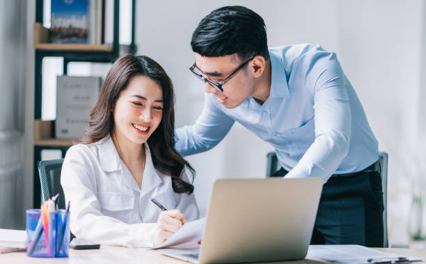 istock Two Asian businesspeople working at office 1384110515