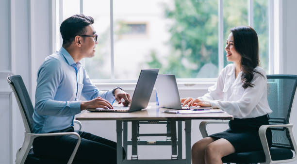 istock Two Asian businesspeople working at office 1384110516