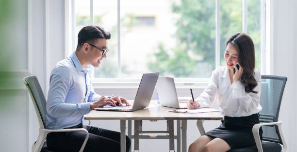 istock Two Asian businesspeople working at office 1384110518