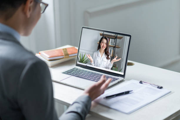 asian male manager interviewing candidates remotely via videocall - filipino ethnicity asian ethnicity women computer imagens e fotografias de stock