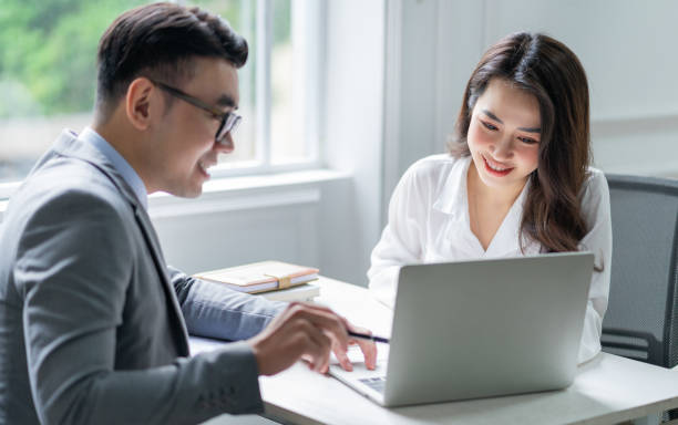 istock Two Asian businesspeople working at office 1384110606