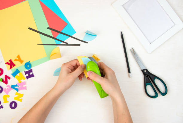 istock Women's hands are stapling paper circles with a stapler. Step by step instructions, top view. Step 12. 1384113877