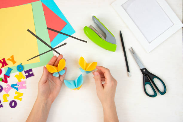 istock Butterflies with their own hands from colored paper. Step-by-step instructions, top view. Step 17. 1384113884