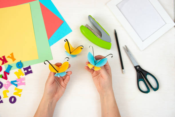 istock Butterflies with their own hands from colored paper. Step-by-step instructions, top view. Step 20. 1384114398