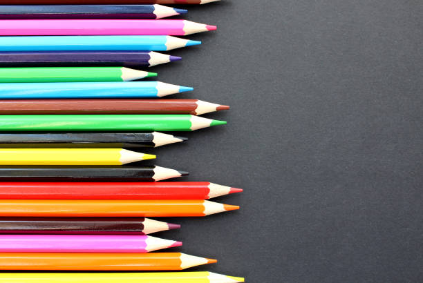 istock Bright colored pencils lie on a black background with space for text. 1384114401
