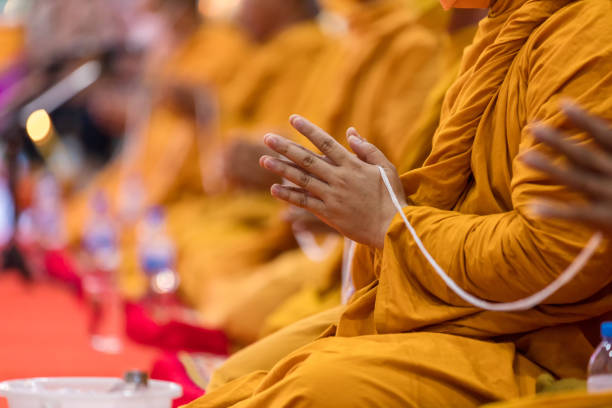 reze de monges em cerimônia de budista na tailândia. muitos monges buda sentam-se no tapete vermelho preparam-se para rezar e fazer cerimônia budista. - monastery buddhism wat east - fotografias e filmes do acervo