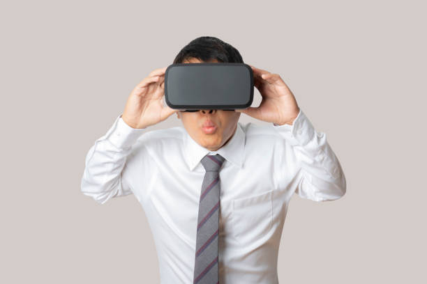 istock Studio portrait man wearing VR Headset isolated on gray background. 1384116375