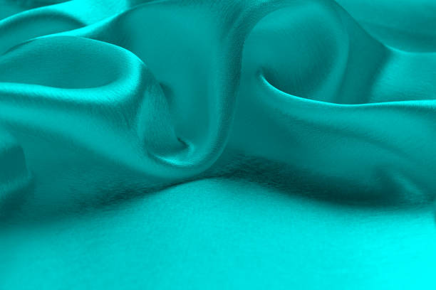 istock Satin fabric turquoise fabric background texture with place for text. 1384117562