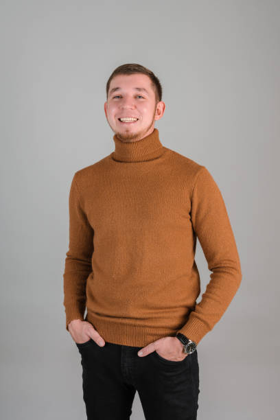 istock A bearded man laughs with his hands in his pockets and standing on a gray background 1384119504