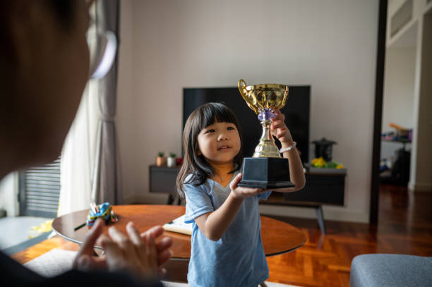 Daughter showing trophy to father
