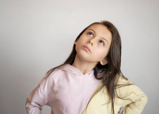 istock Cute little girl looking up, just have an idea, Copy space 1384130761