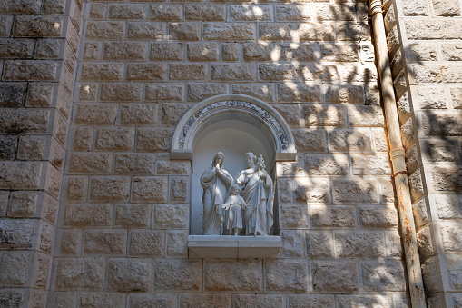 Nazareth, Israel, February 12, 2022 : The religious bas-relief in the wall of the St. Josephs Church - Roman Catholic church built in the Romanesque Revival style in 1914 on the site of old churches in Nazareth, northern Israel