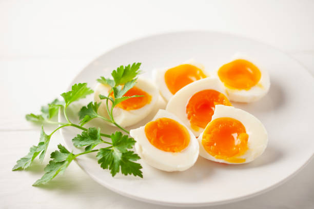 istock Boiled eggs  with parsley leaves  in a plate on a gray background. 1384131695