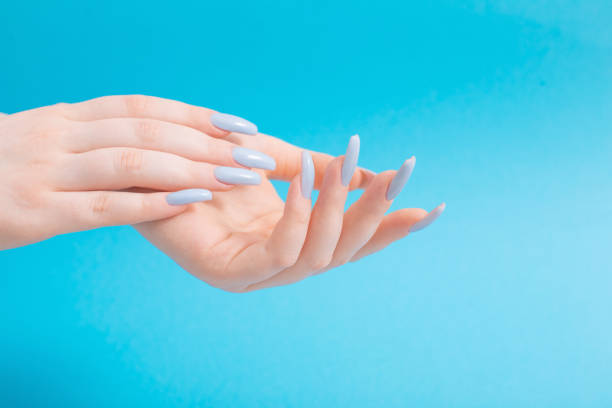 istock female hands with beautiful blue manicure  on blue background 1384131819