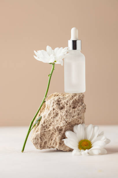 Cosmetic serum bottle on travertine stone podium. Minimal mockup background.