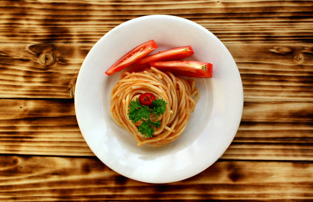 The plate contains swirled pasta with sauce.